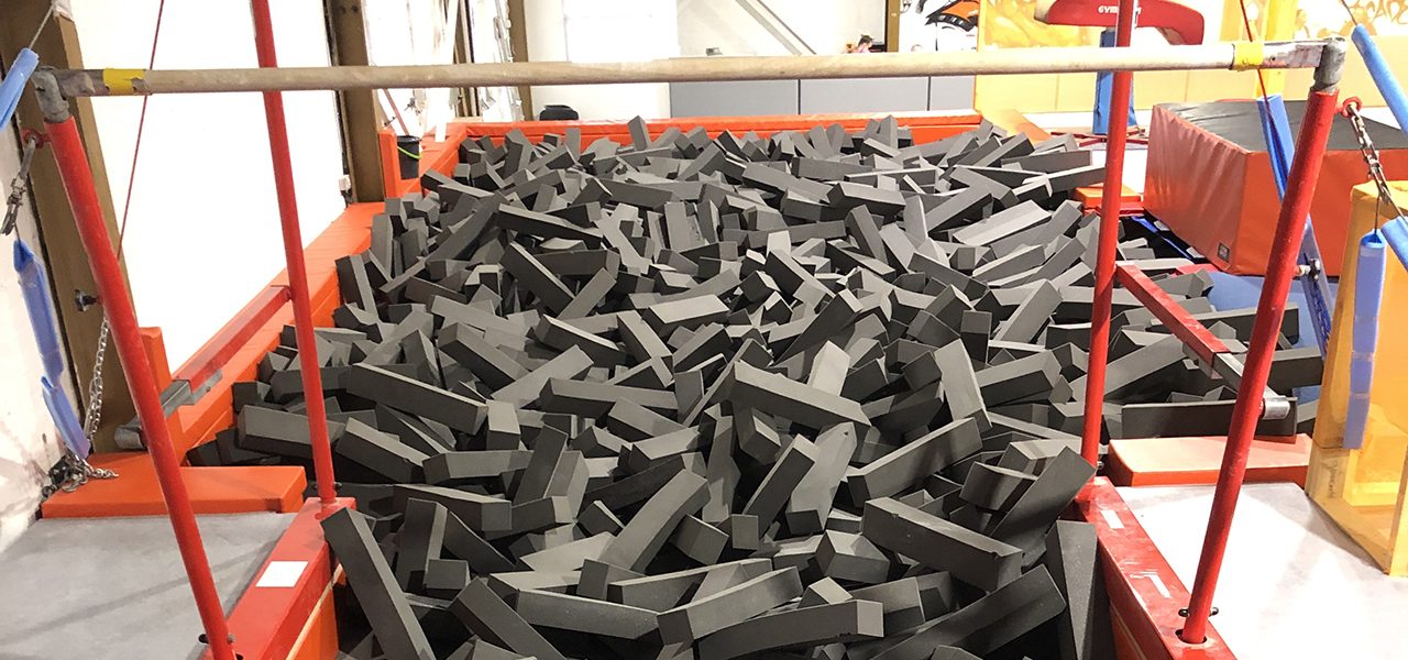 Grey foam blocks beneath gymnastics apparatus