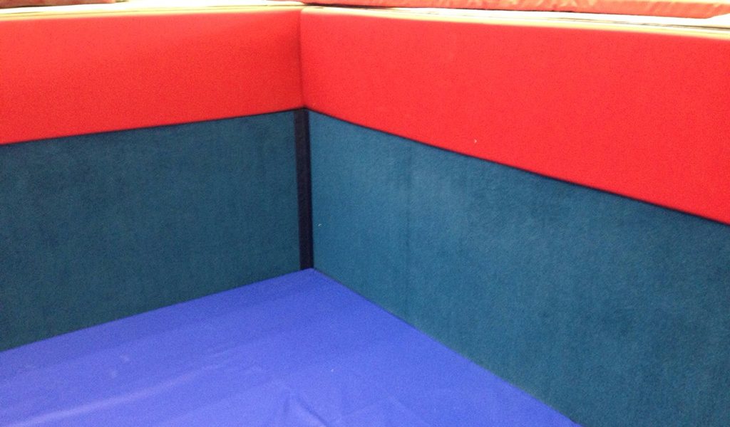 Red and blue wall padding with a blue floor mat