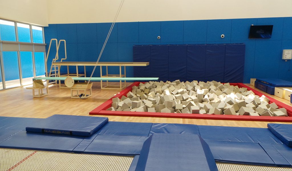 A foam pit surrounded by blue matting