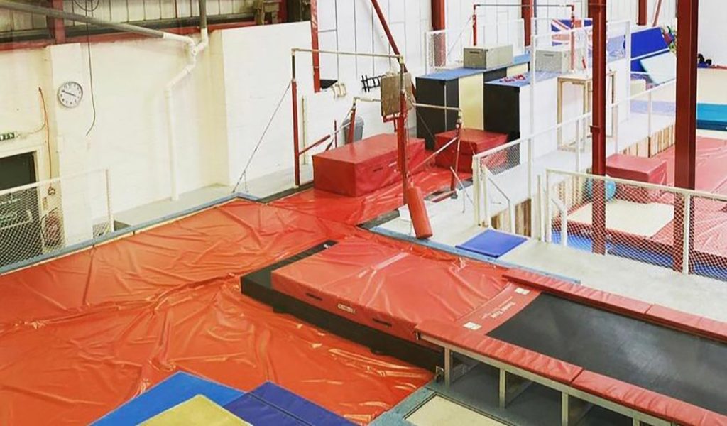Gymnastics bars with orange landing mats